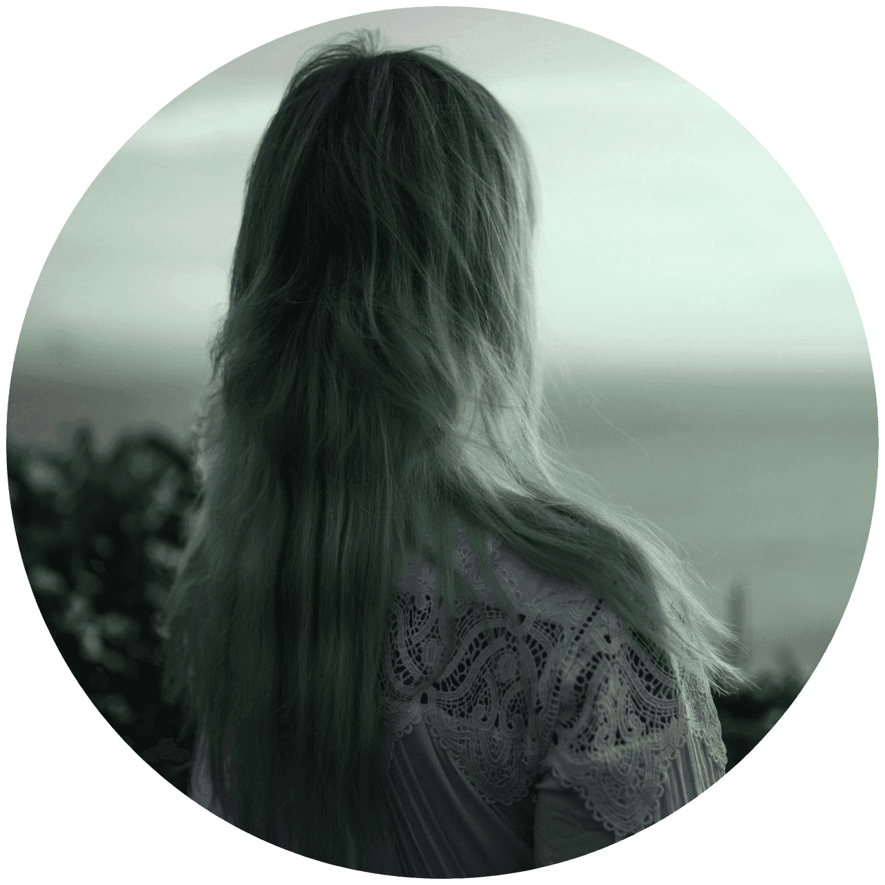 Frau mit langen Haaren von hinten schaut in die Ferne